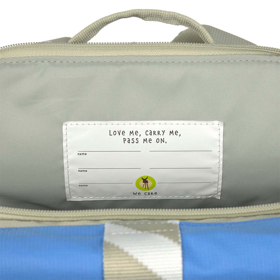 Detail van het label aan de binnenkant van de Lässig schoolrugzak met de tekst 'Love Me, Carry Me, Pass Me On'.