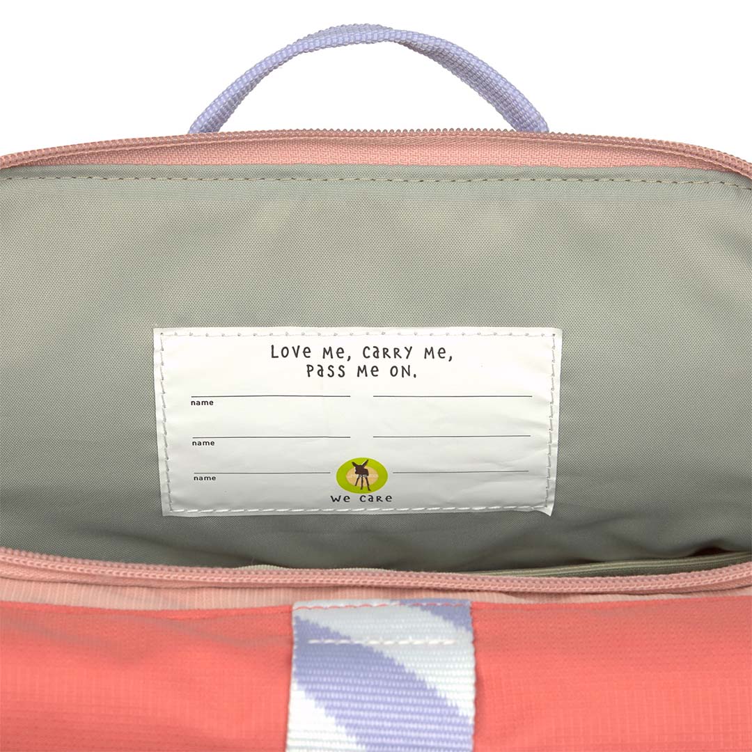 Detail van het interne label in de Lässig schoolrugzak met de tekst "Love me, Carry me, Pass me on."