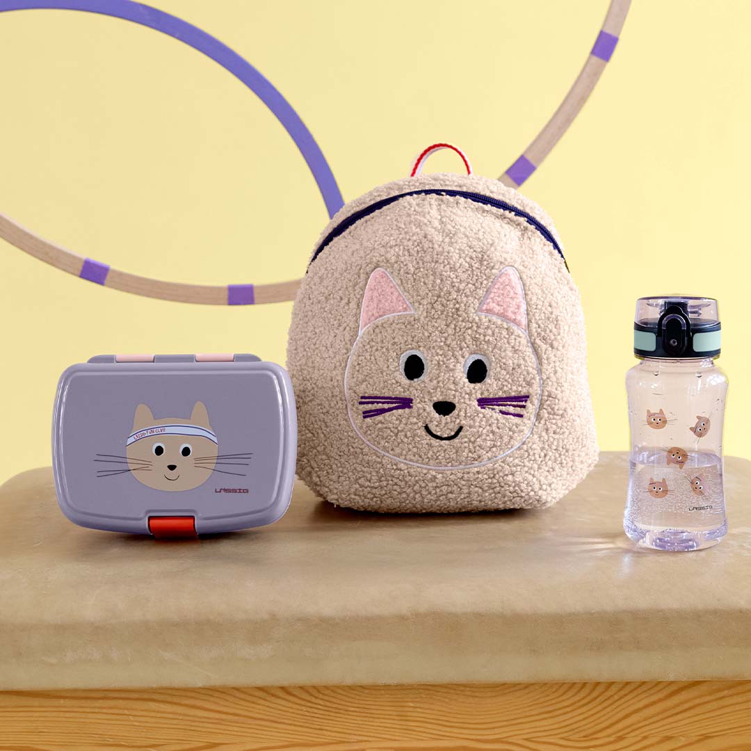 Lässig lunchbox, rugzak en drinkfles met katten thema op een tafel.