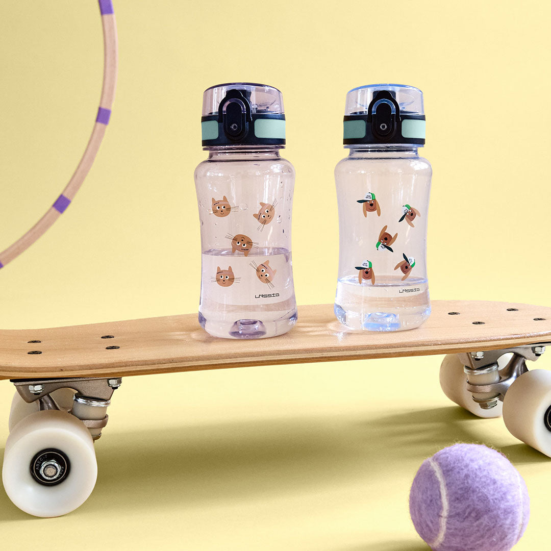 Twee Lässig kinder drinkflessen, één met katten en één met honden, op een skateboard.