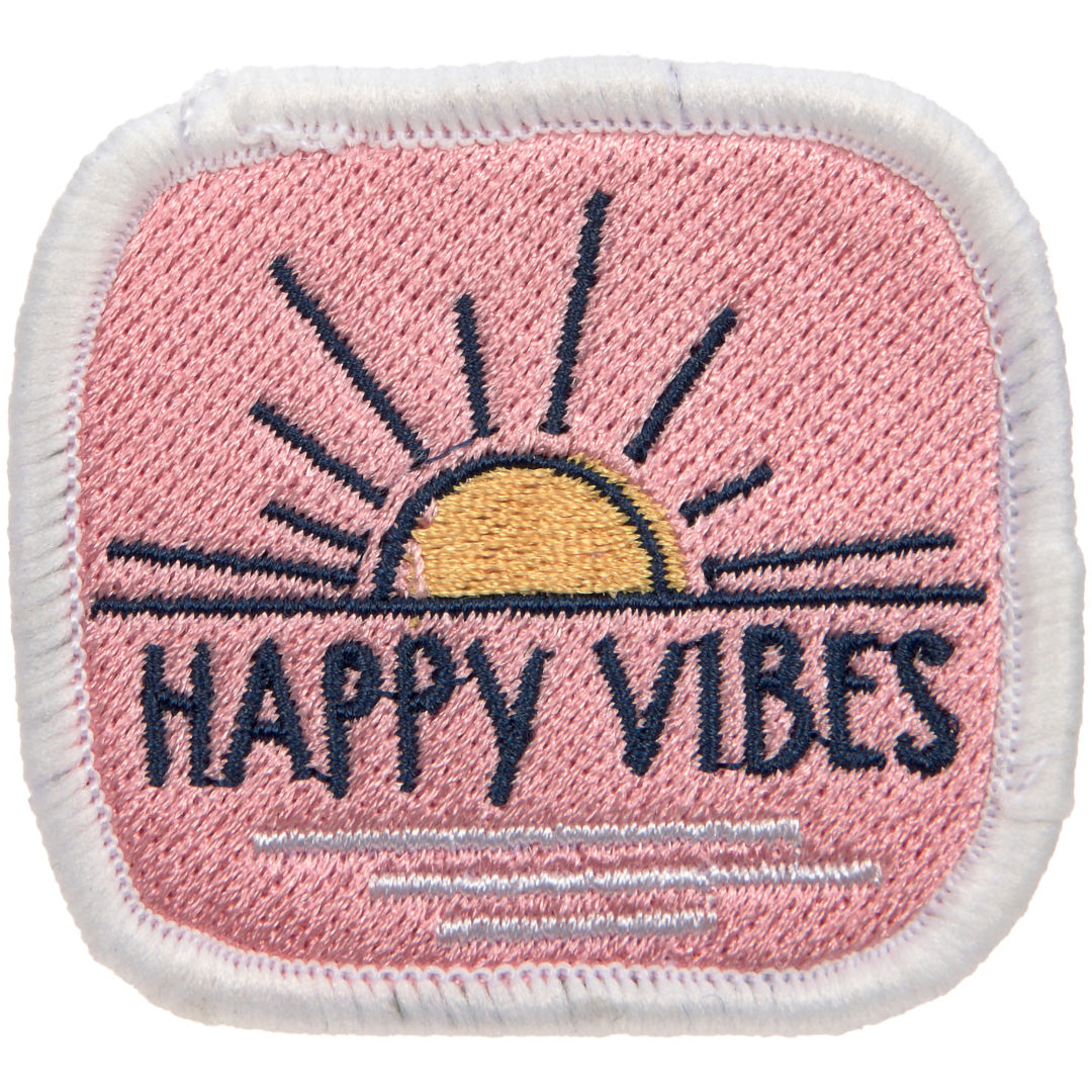 Detail van een vierkante patch met de tekst 'HAPPY VIBES' en een opkomende zon op een roze achtergrond.