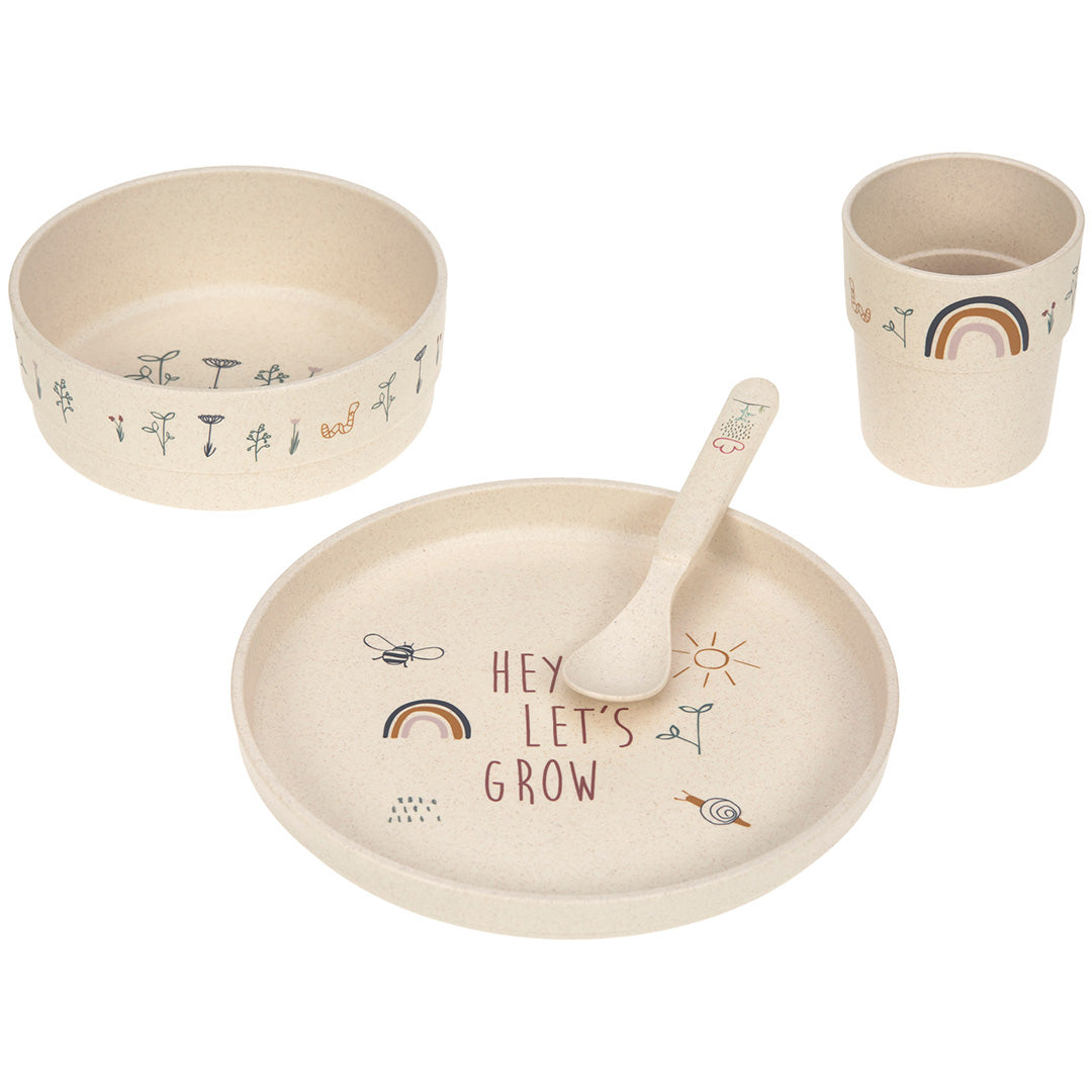 Lässig babyserviesset met beige bord, kom, beker en lepel, versierd met een regenboog, bladeren en de tekst 'HEY LET'S GROW'.