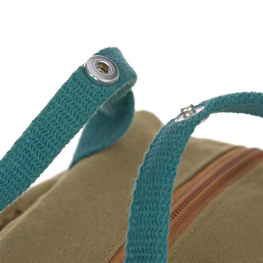 Close-up van de teal handvatten van de kleuterrugzak met drukknopen.