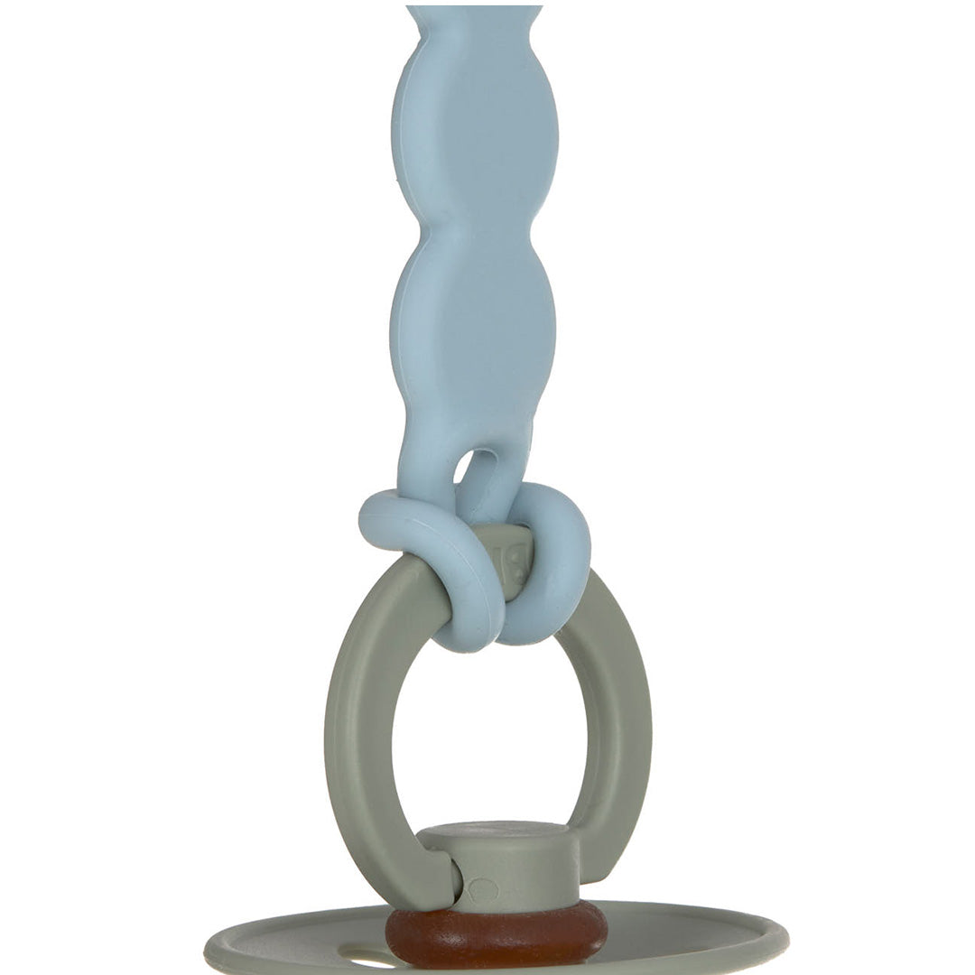 Detail van het lichtblauwe speenkoord dat is bevestigd aan een grijze ring van een speen.