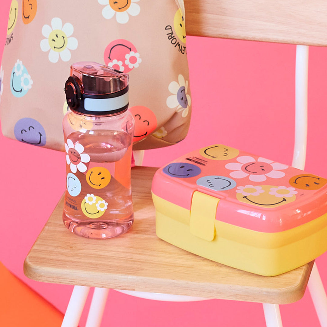 Lässig kinderdrinkfles met bijpassende lunchbox en tas met Smileyworld print op een houten stoel.