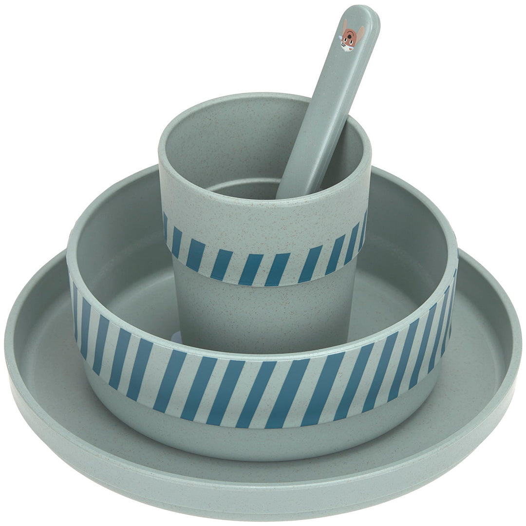 Gestapelde groene lässig babyserviesset met gestreepte kom en beker, en een lepel.