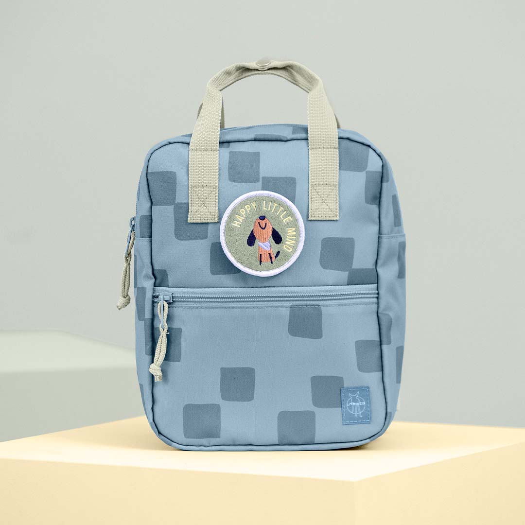 Voorkant van de blauwe Lässig kleuterrugzak met geometrisch patroon en een hondenpatch.