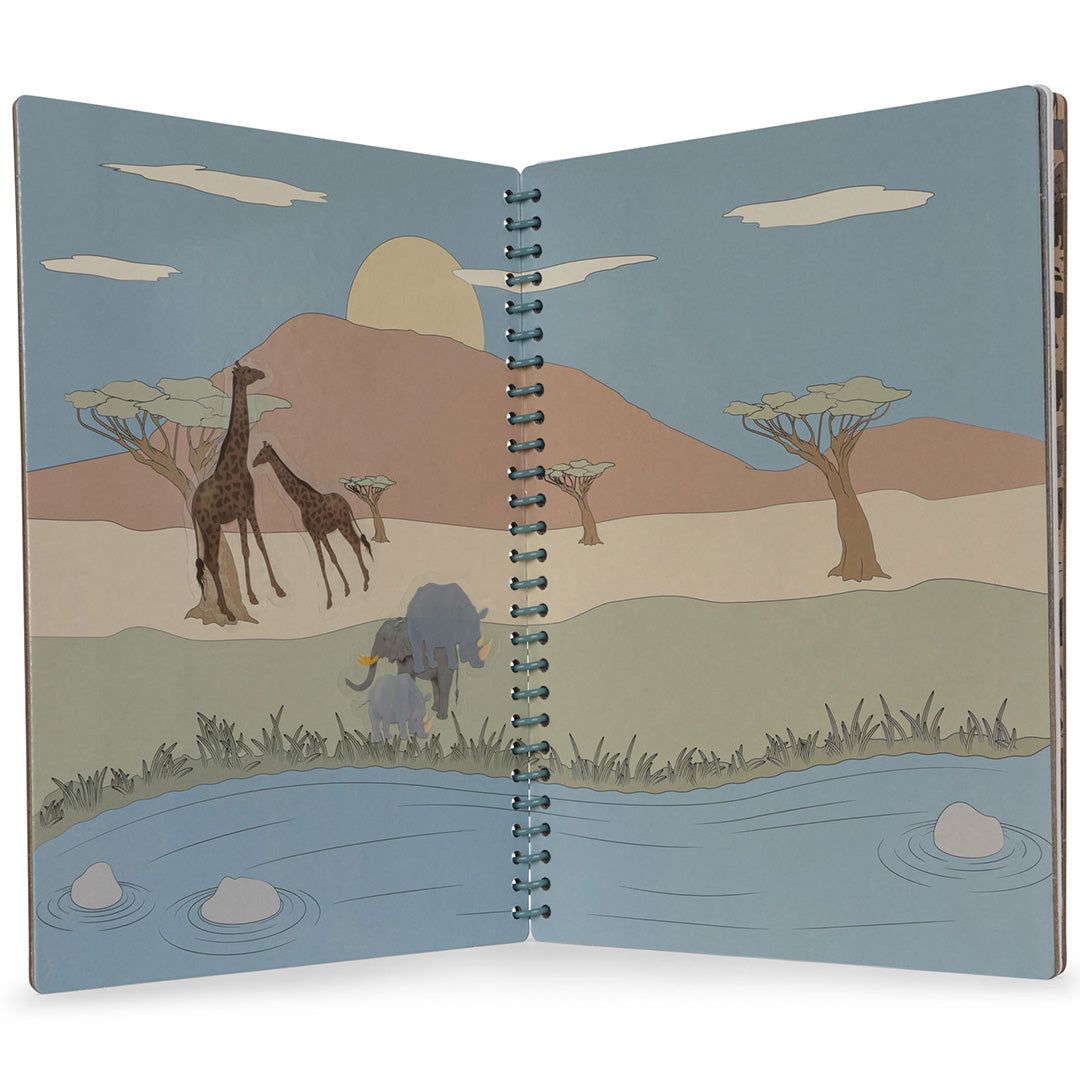 Open Konges Sløjd stickerboek met een safari-illustratie van giraffen, olifanten en bomen bij een rivier.