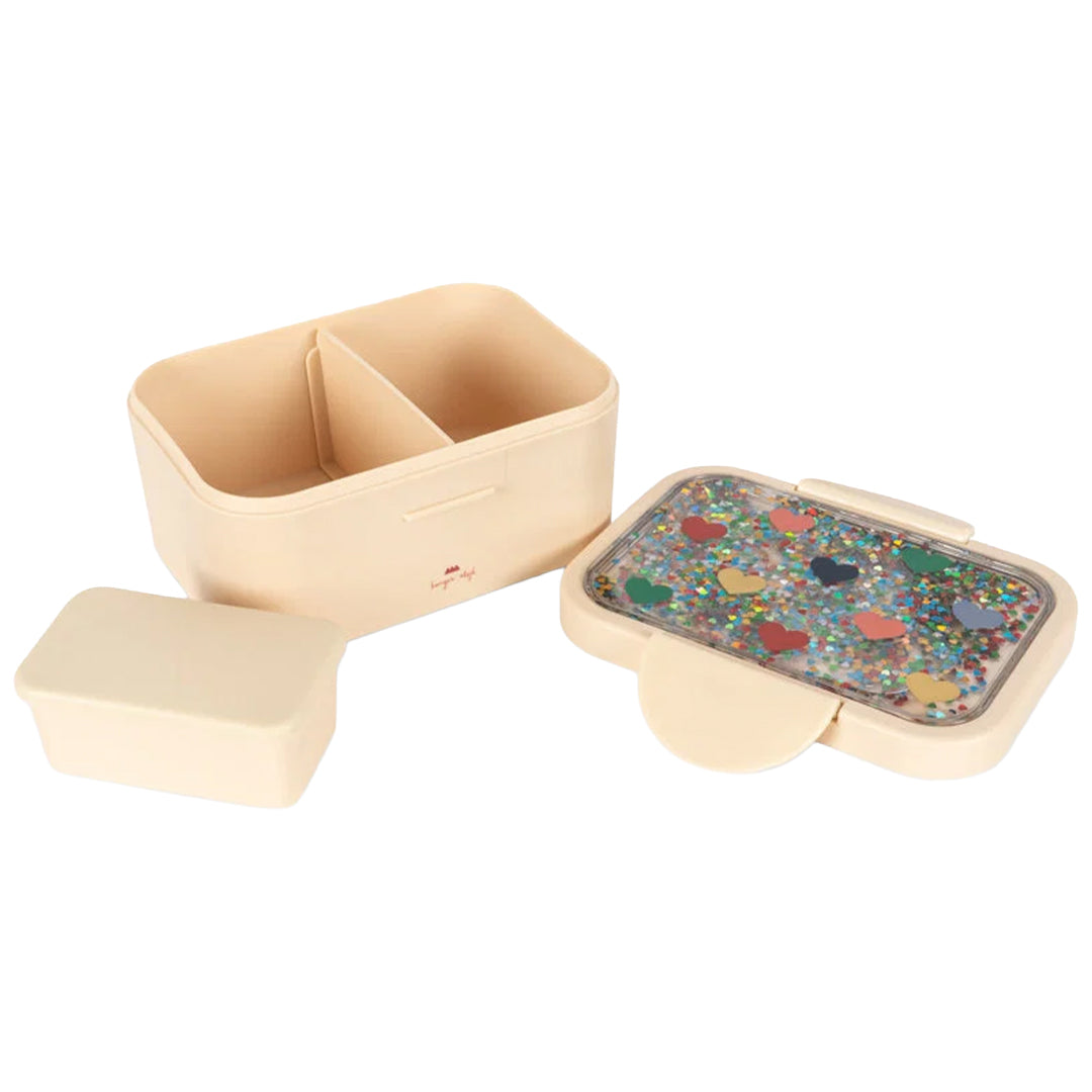 Konges Sløjd kinderbroodtrommel in beige, open met een deksel vol glitter en harten.