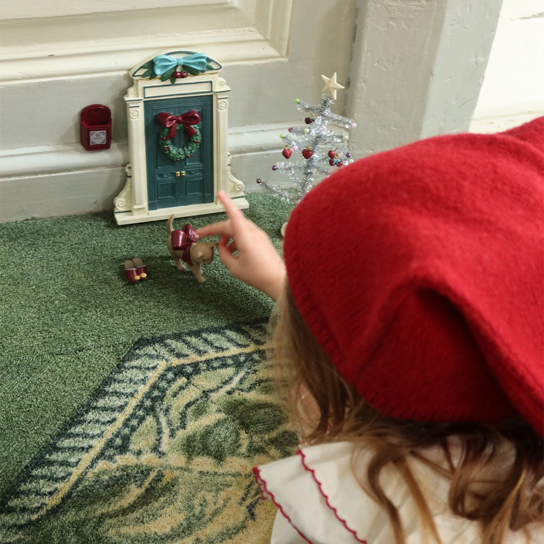 Een kind wijst naar het miniatuur katje van de konges sløjd kerstdecoratie set.