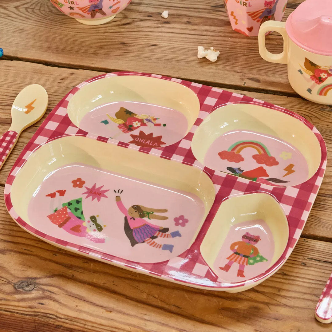 Rice roze vakjesbord voor kinderen met superheldenfiguren op een houten tafel, met bijpassende lepel.