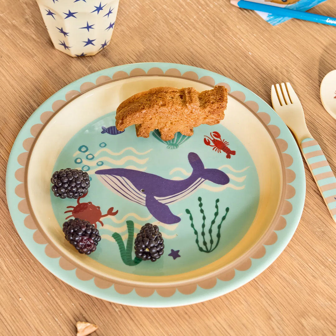 Rice kinderbord met onderwaterwereld thema met een cakeje en bramen erop, op een houten tafel.