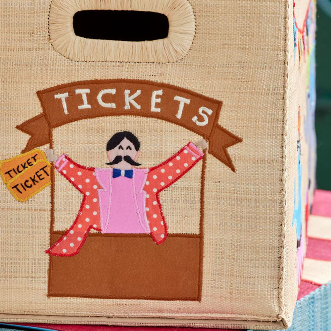 Detail van de raffia opbergmand met een geborduurde ticketkraam en de tekst 'TICKETS'.
