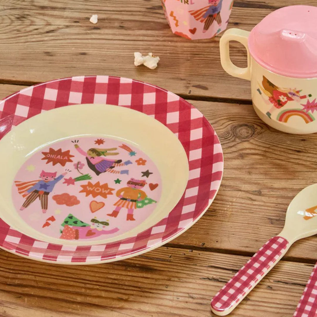 Rice kinderbord met superheldenfiguren en geruite rand, samen met een bijpassende beker en lepel.
