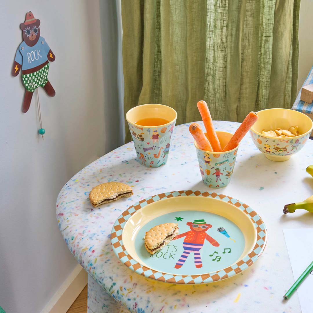 Rice kinderbeker met 'music band' patroon op een tafel met snacks en een bijpassend bord.