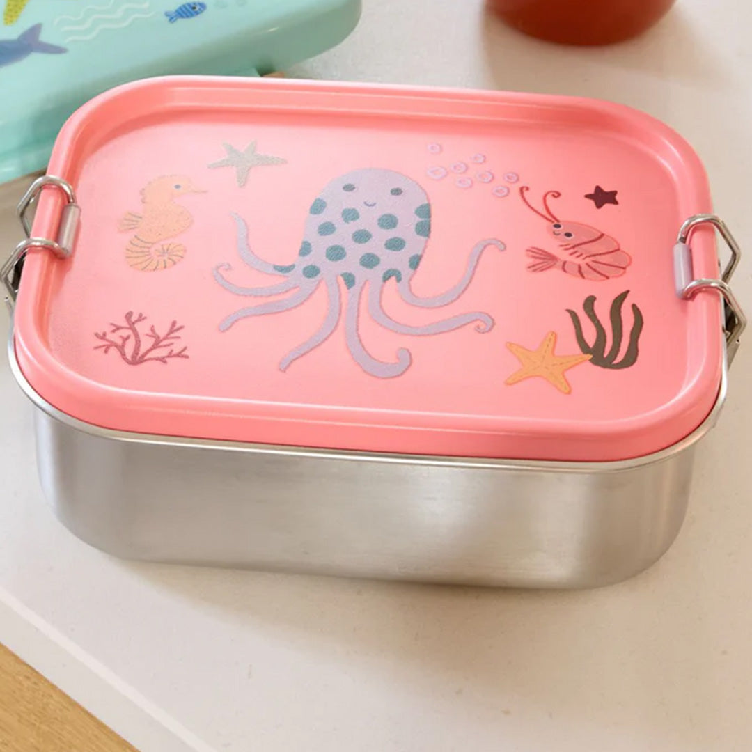 rice roestvrijstalen broodtrommel met roze deksel met zeedieren, gesloten op een lichte ondergrond.