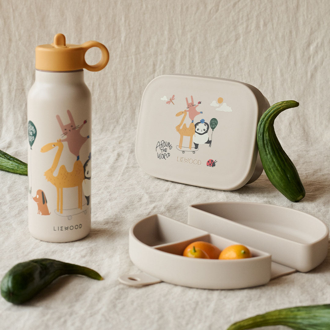 Liewood siliconen snackdoos en waterfles met 'Around the World' dierenprint op een stoffen ondergrond.