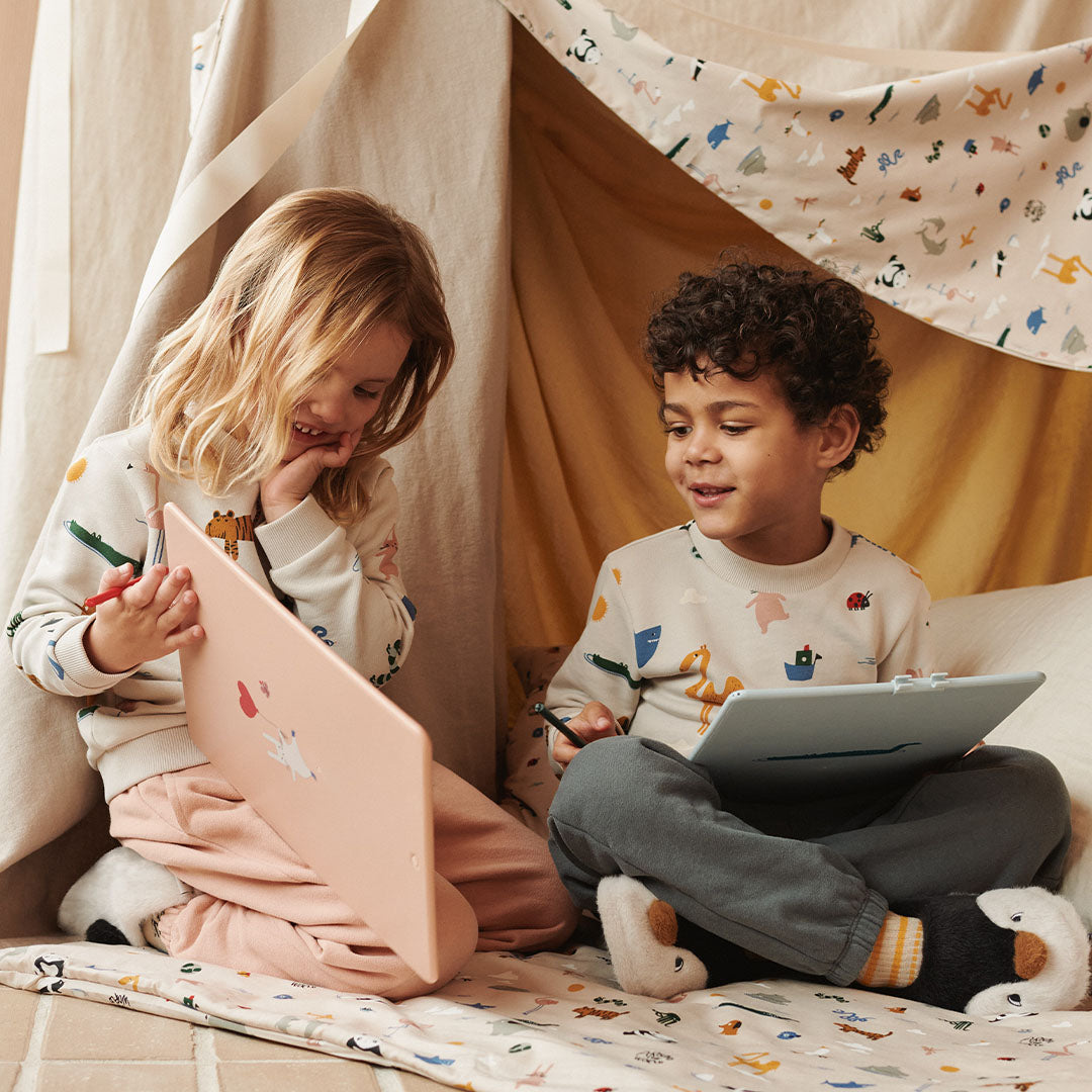 Twee kinderen zitten in een speeltent, waarbij de jongen de duifblauwe tekentablet vasthoudt.