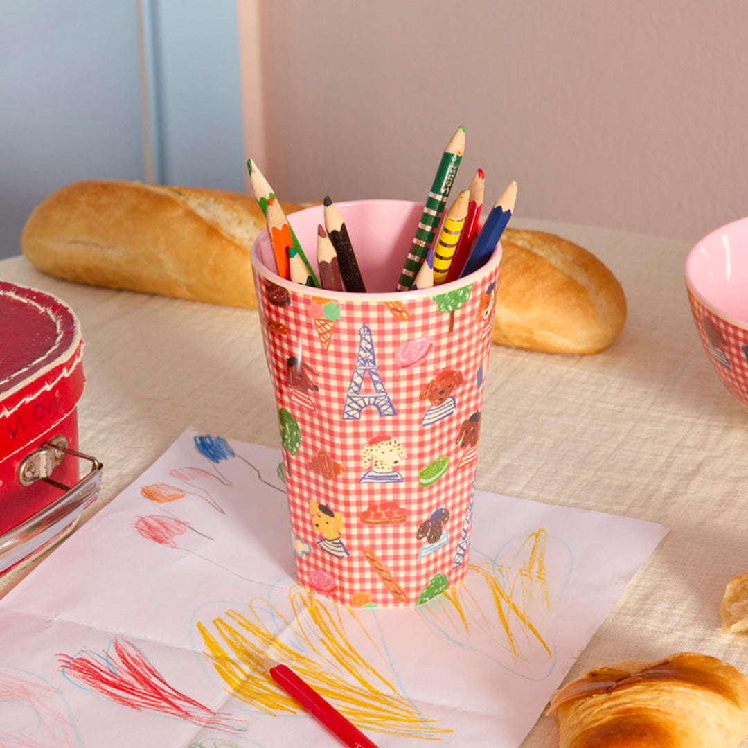 rice kinderbeker met Parijs-thema, gevuld met kleurpotloden op een tafel met een kindertekening.