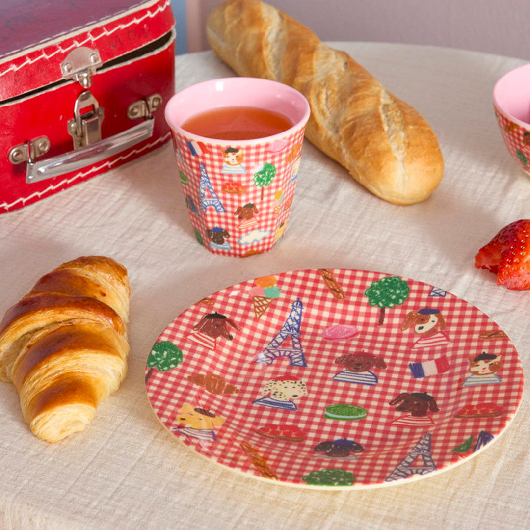 rice kinderbord met Parijs-thema, een croissant en een beker met sap op een tafel.