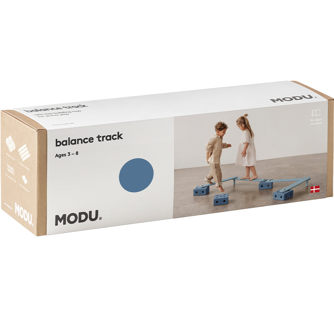 De verpakking van de Modu evenwichtsset, een bruine kartonnen doos met productafbeelding en logo.