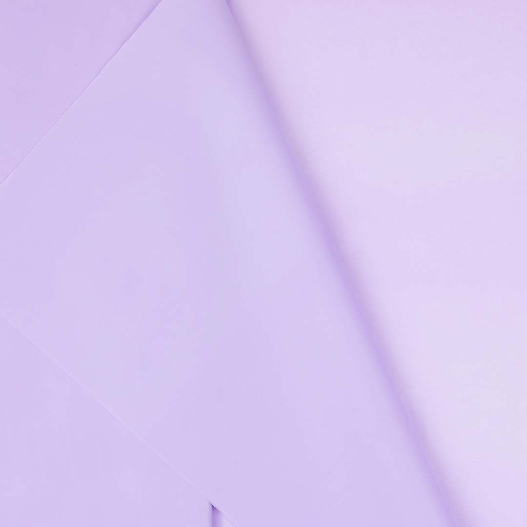 Detailopname van het lavendelkleurige plastic tafelkleed met lichte vouwen.