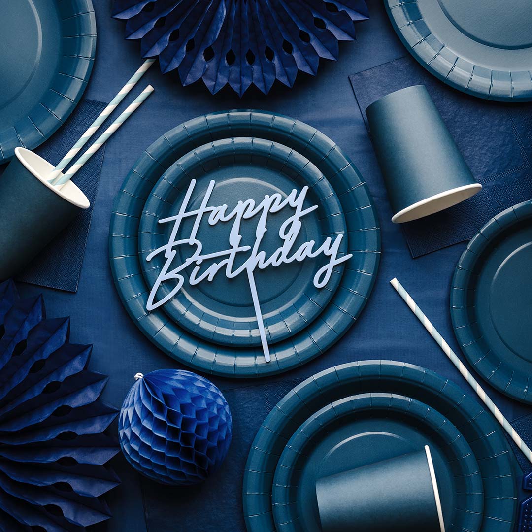 Een overzicht van donkerblauwe PartyDeco feestartikelen, waaronder borden, bekers, rietjes en decoraties, met een 'Happy Birthday' taarttopper.