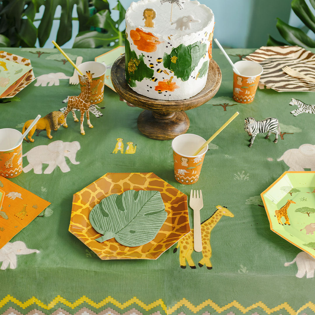 Gedekte feesttafel met het PartyDeco groene safari tafelkleed en bijpassende decoraties.