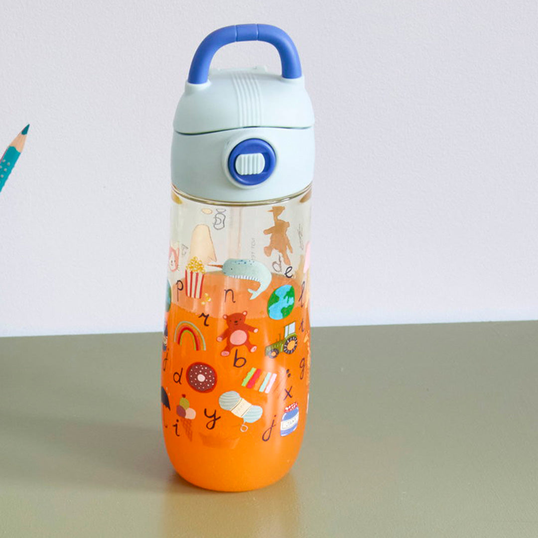rice kinder drinkfles met blauwe dop en ABC-illustraties, gevuld met oranje drank, op een tafel.