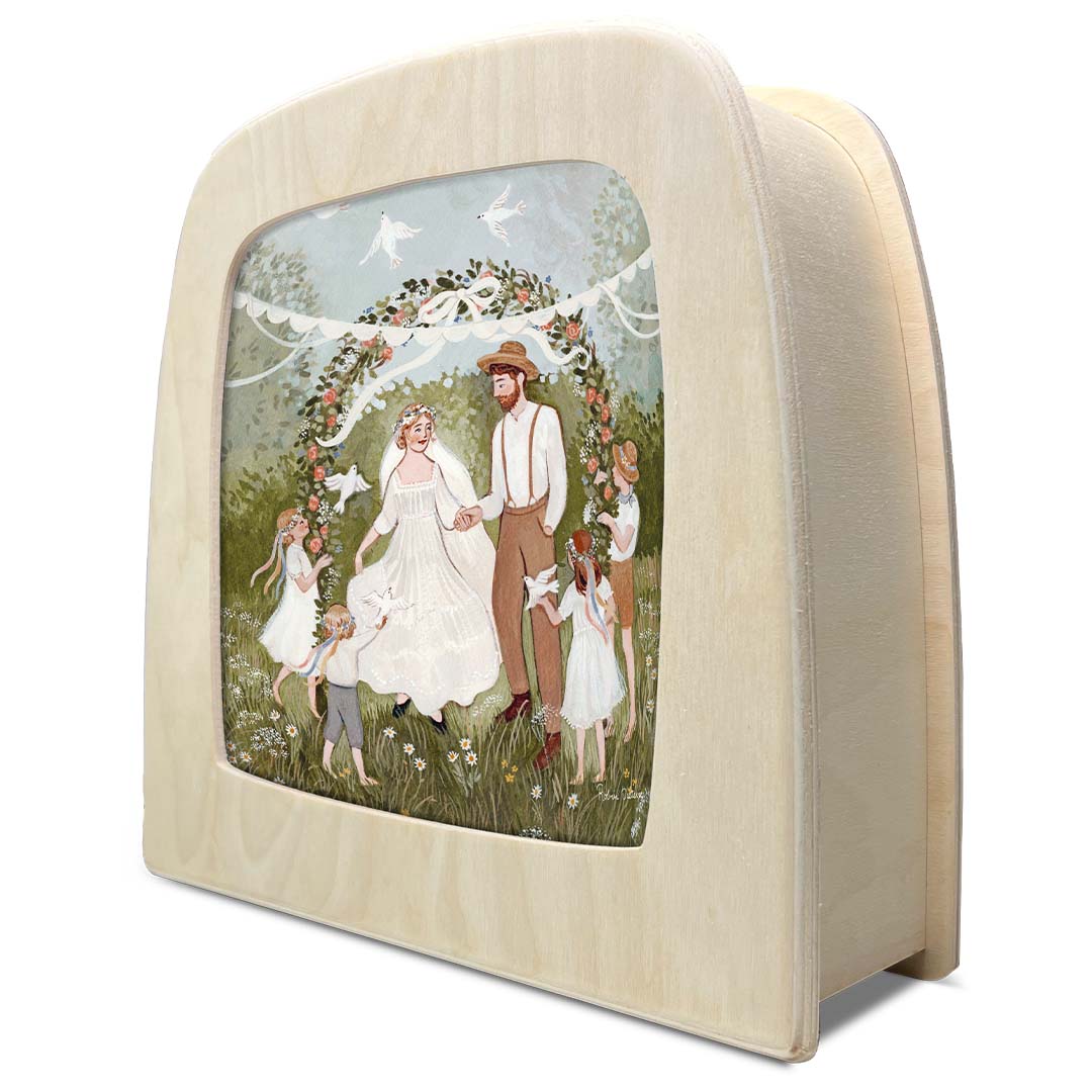 Schuin aanzicht van de toverlux toverplaat 'Belofte' met een bruiloftsscène in een licht houten frame.