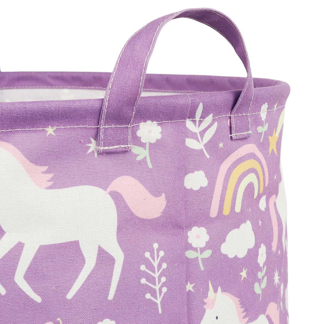 Detail van de bovenrand en een handvat van de a little lovely company opbergmand met eenhoorn- en regenboogprint.
