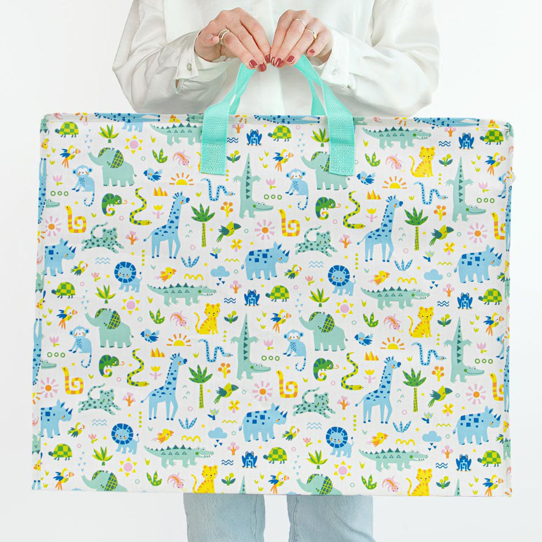 Een persoon houdt de a little lovely company XL opbergtas met jungle dierenpatroon vast om het formaat te tonen.