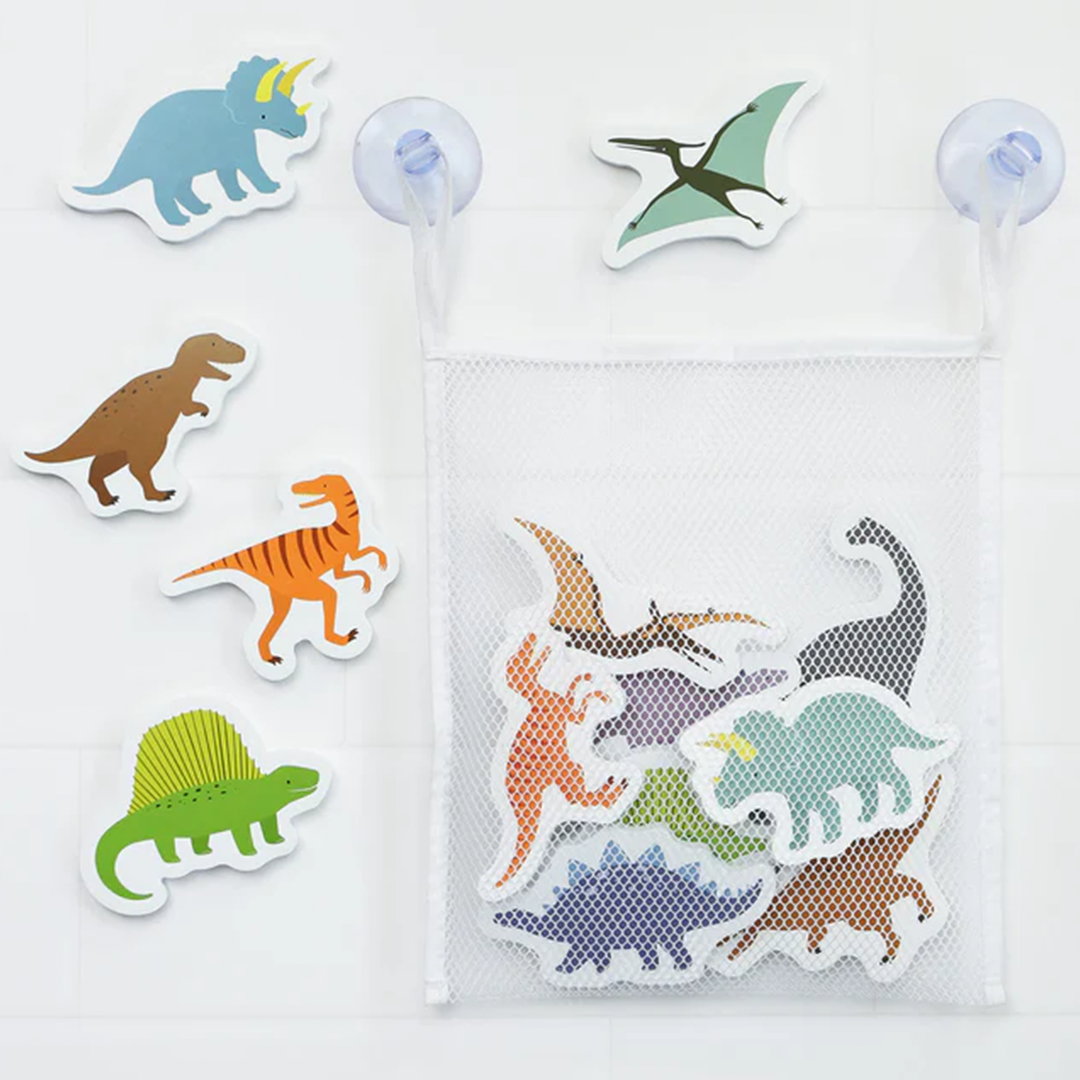 Diverse kleurrijke schuim dinosaurussen badfiguren op een witte tegelwand met een opbergzakje.