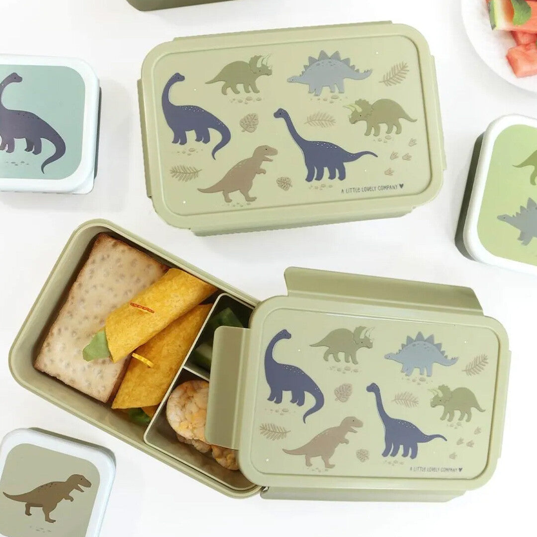 Twee A Little Lovely Company beige broodtrommels voor kinderen met dinosaurusillustraties, waarvan één gevuld met lunch.