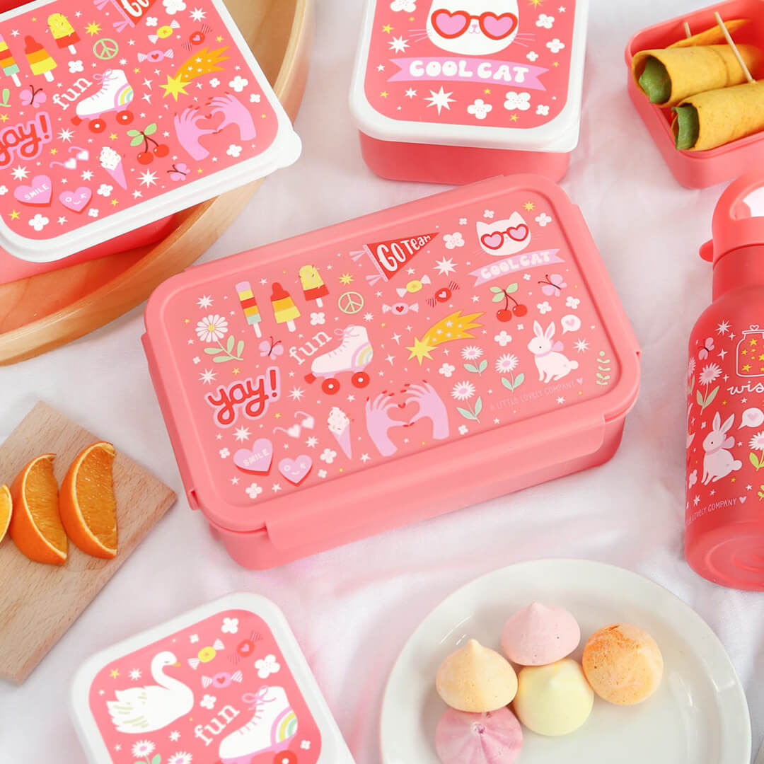 a little lovely company roze broodtrommel met 'fun' thema, omringd door bijpassende snackdoosjes en een drinkfles.