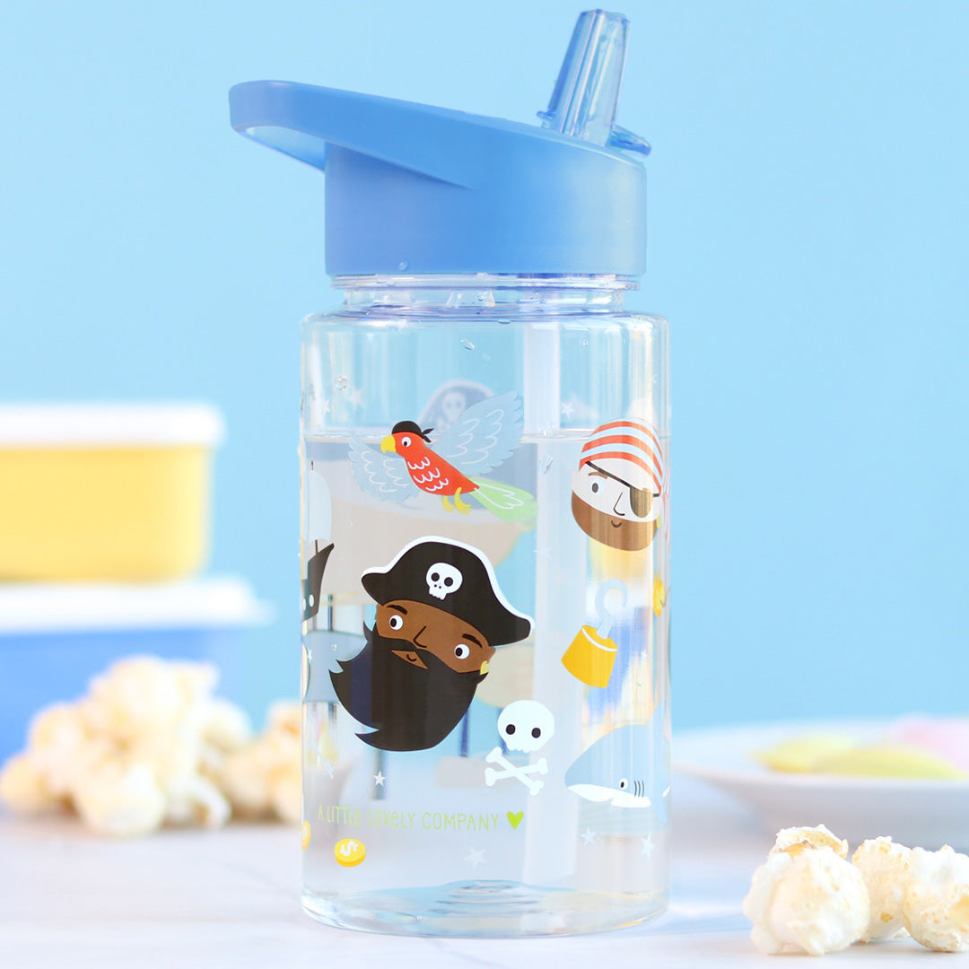 a little lovely company kinder drinkfles met piratenfiguren en blauwe rietjesdop, staand op tafel met popcorn.