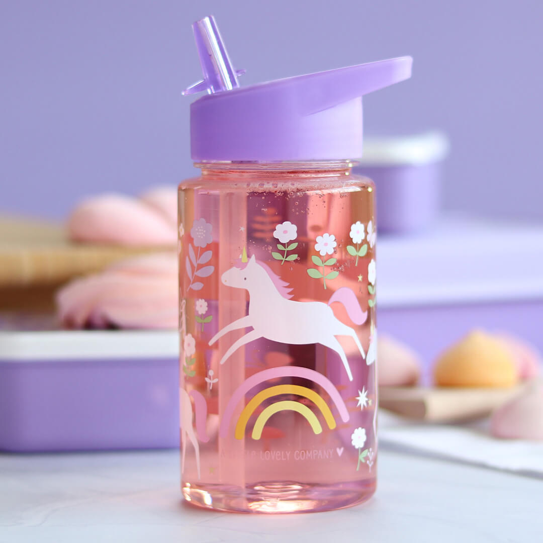 A little lovely company drinkfles voor kinderen met rietje, gevuld met roze vloeistof, op een paarse achtergrond.