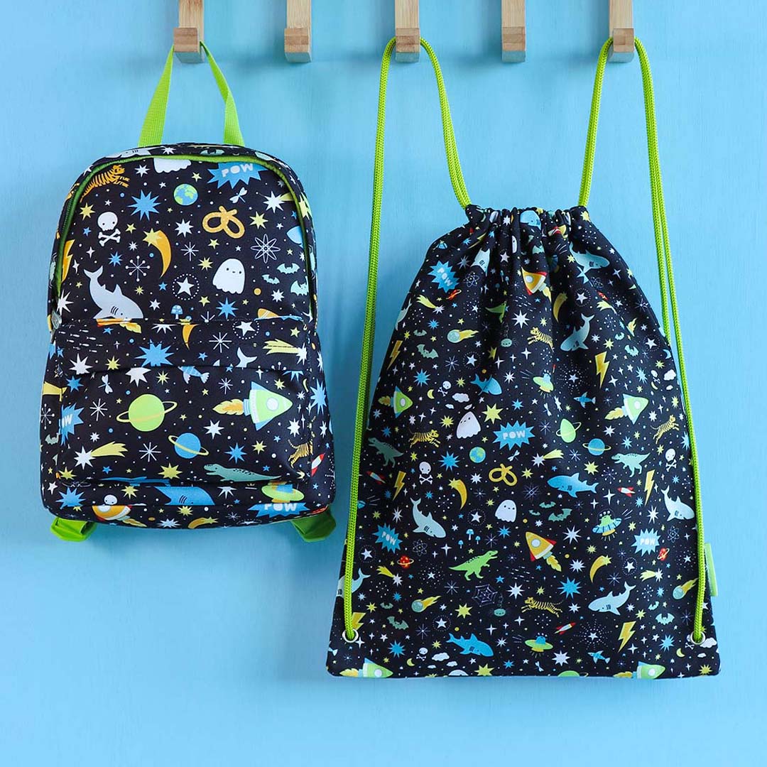 De a little lovely company kindergymtas en een bijpassende kinderrugzak met galaxy- en dierenpatroon hangen aan haken.