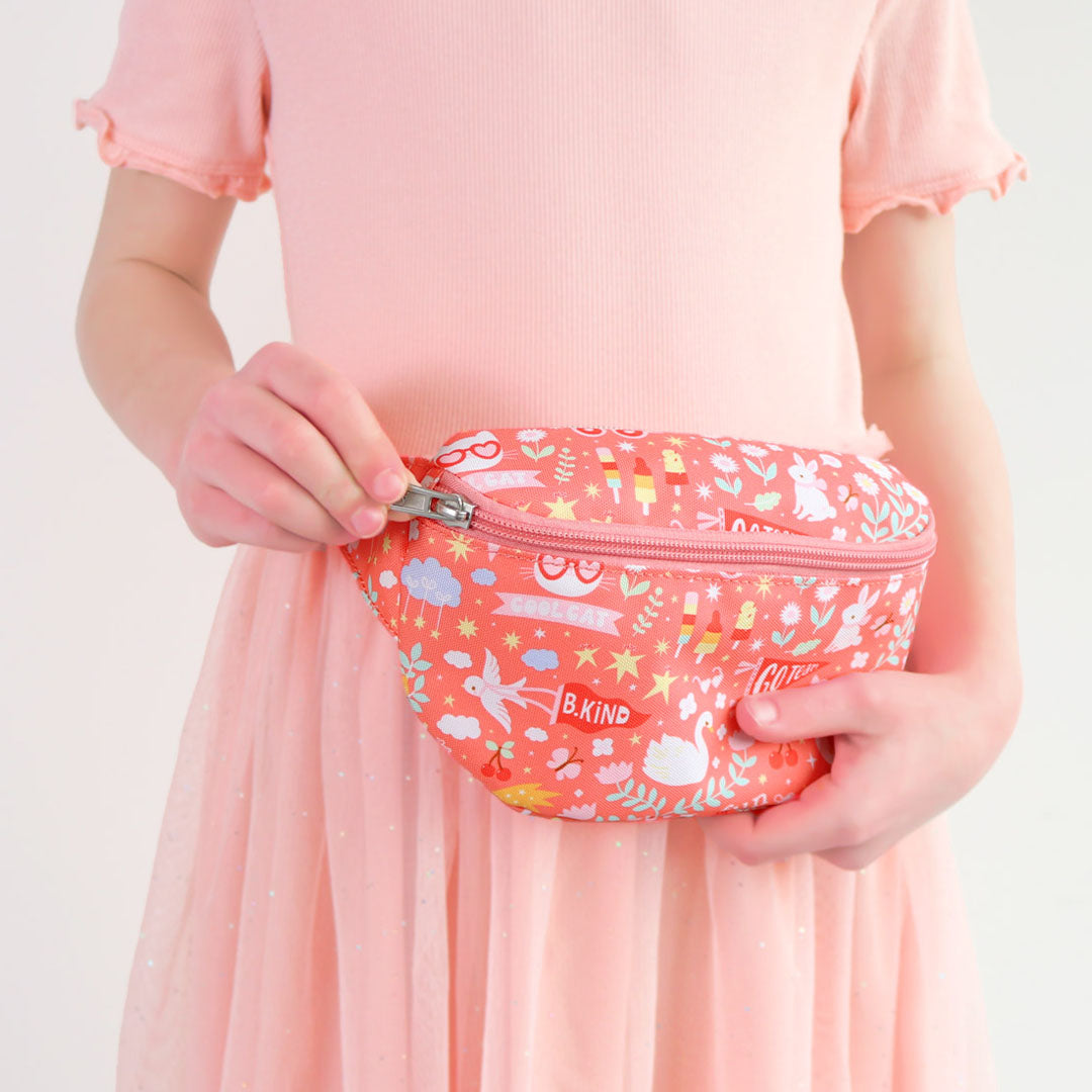 Een kind houdt de roze kinder heuptas van a little lovely company vast en opent de rits.