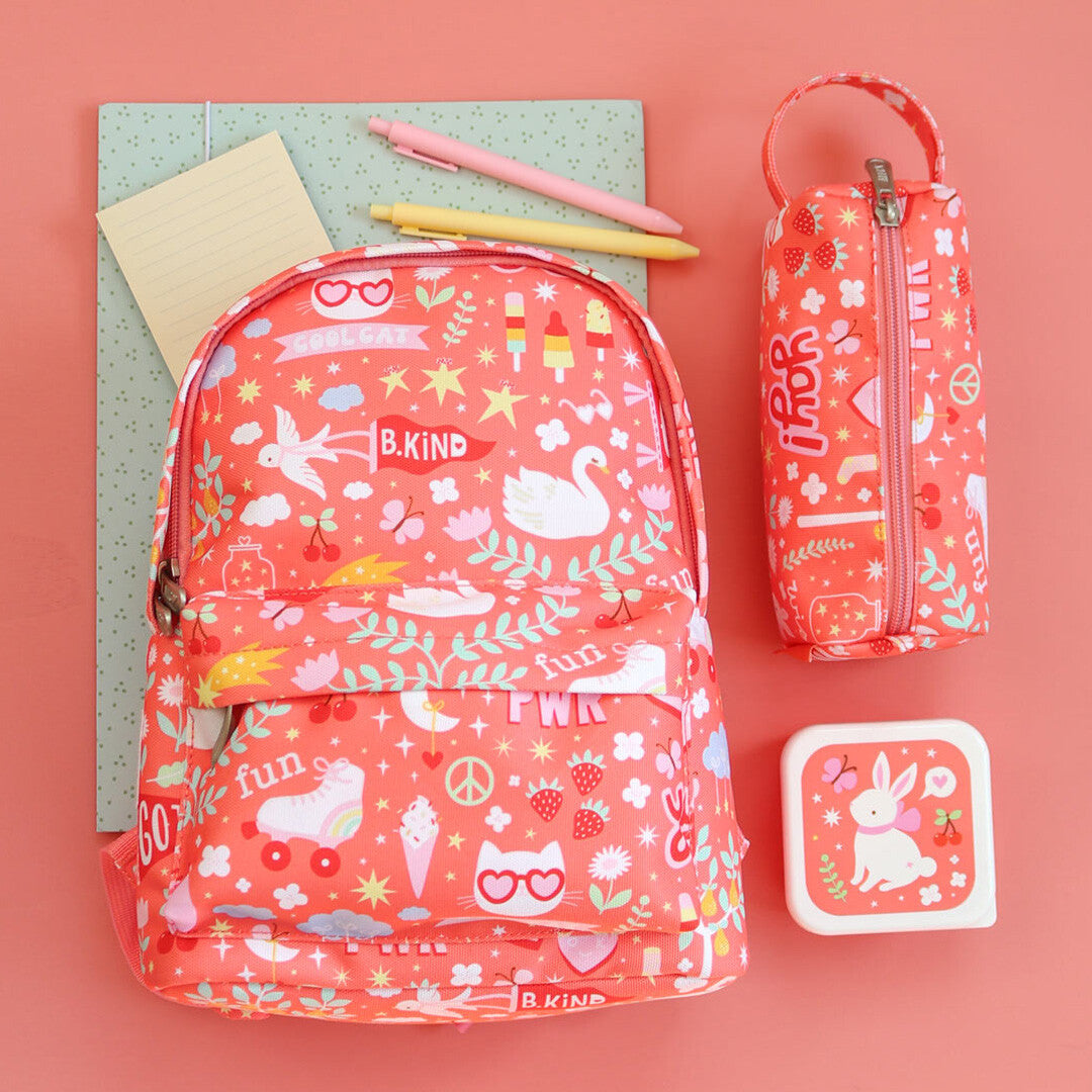 De roze a little lovely company kleuterrugzak met bijpassende etui en lunchbox, liggend op een roze ondergrond.