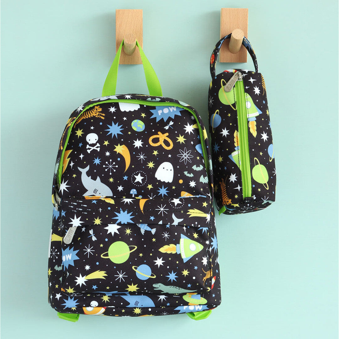 a little lovely company kleuterrugzak en bijpassend etui met galaxy-thema hangen aan houten haken.
