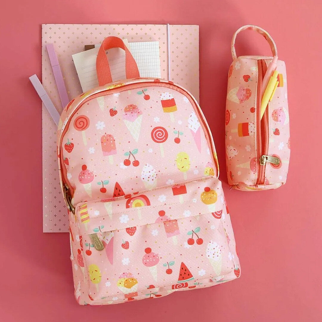 a little lovely company kleuterrugzak en bijpassend etui met ijsjespatroon, liggend op een roze ondergrond met schrijfwaren.