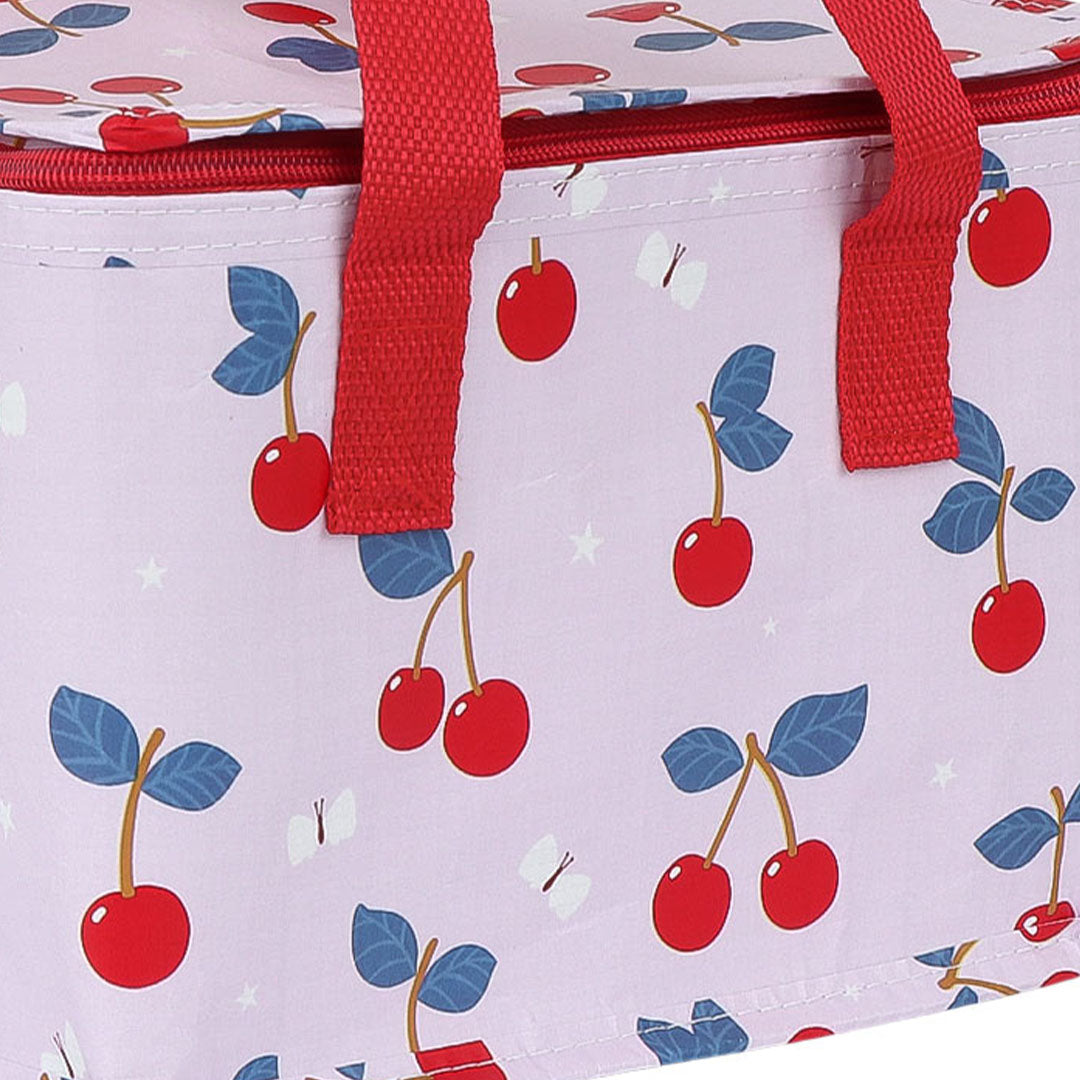 Detail van de a little lovely company roze koeltas met kersen- en sterrenpatroon en rode handvatten.