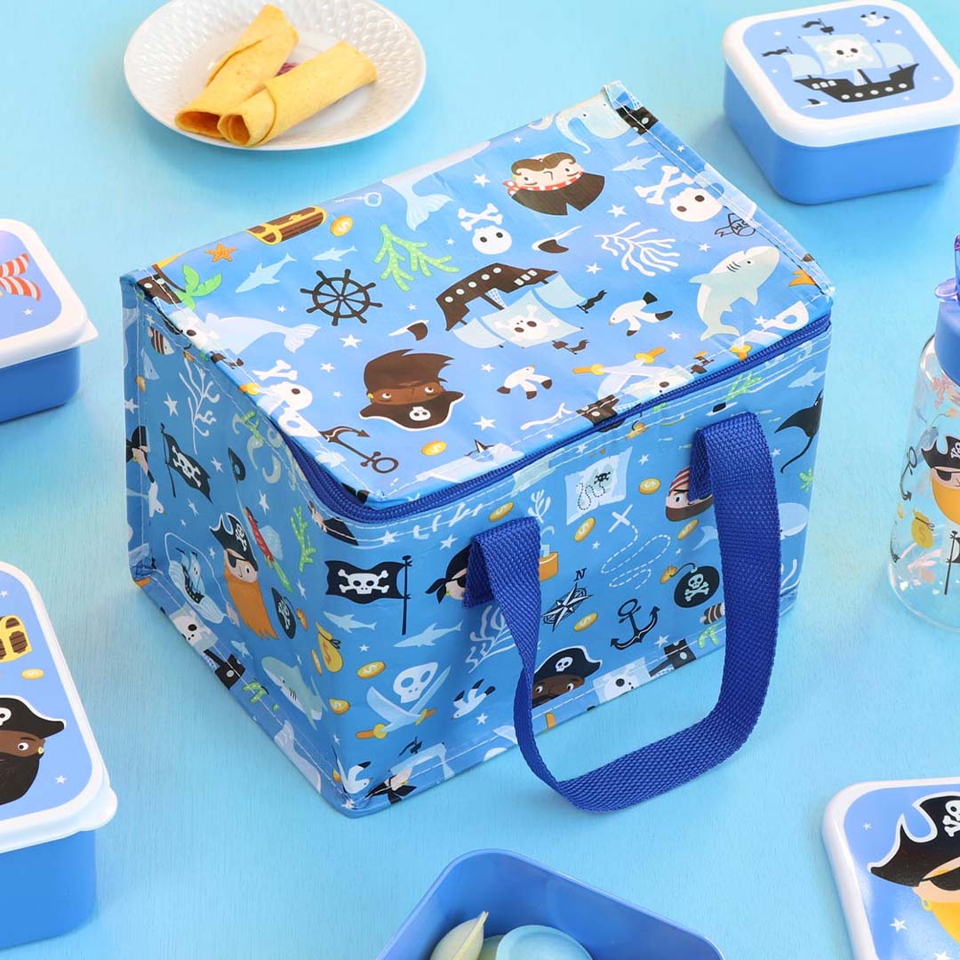 a little lovely company blauwe koeltas met piratenprint, gesloten en omringd door bijpassende lunchboxen.