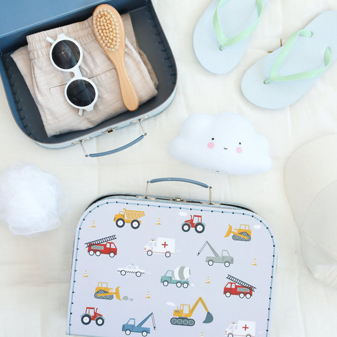 Een open a little lovely company kinderkoffer met voertuigenpatroon, gevuld met kleding en accessoires, naast een gesloten koffer.