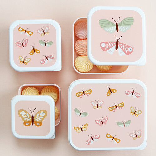 Vier roze A Little Lovely Company broodtrommels met vlinderpatronen, waarvan twee open met snoepjes erin.