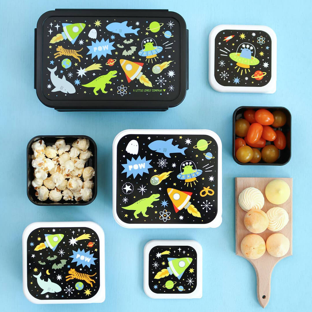 Een a little lovely company broodtrommelset met galaxy-thema, met verschillende open en gesloten lunchboxen gevuld met snacks op een blauwe ondergrond.
