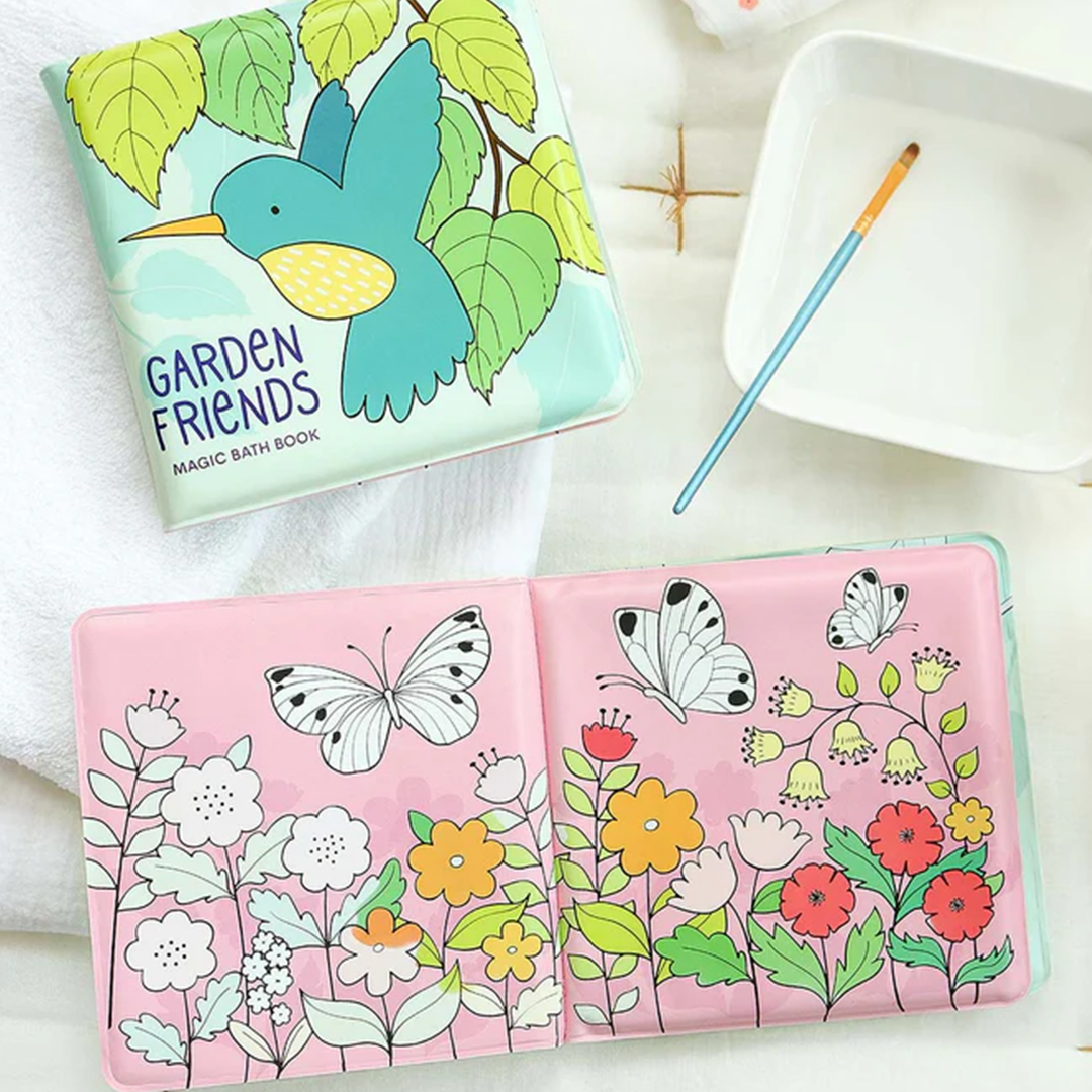 Een open a little lovely company magisch badboekje 'Garden Friends' met vlinders en bloemen, naast een kwastje en water.