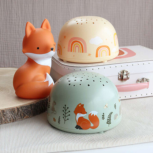 Twee a little lovely company nachtlampen en sterprojectoren, één beige met regenbogen en één groen met vossen, naast een vossenlampje.