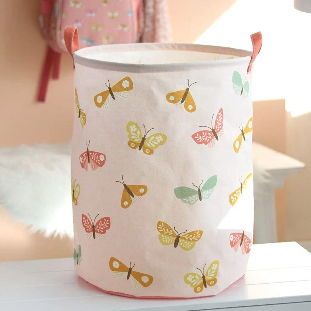 A little lovely company roze opbergmand met vlinderpatroon in een kamerinterieur.